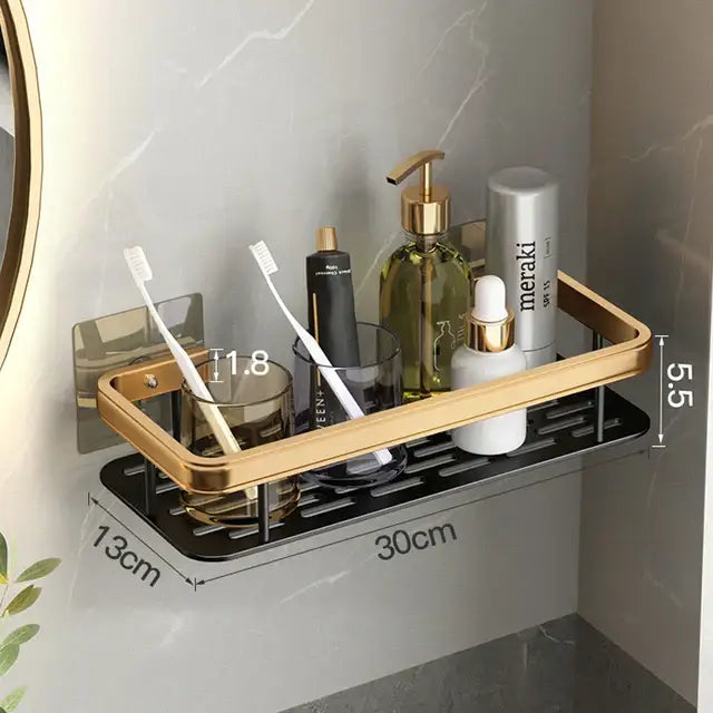 Gold-finished aluminum corner bathroom shelf with black grated base holding toothbrushes and toiletries by decorbites