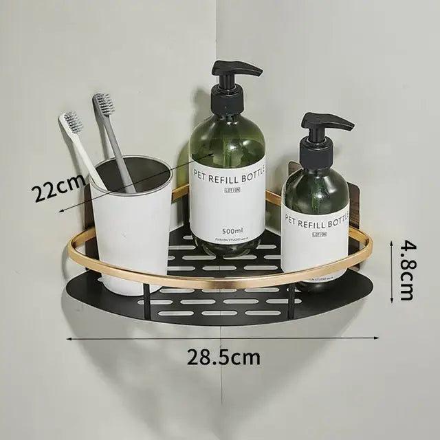 Modern aluminum corner bathroom shelf with black metal base gold-toned rim holding toothbrushes and green pump bottles