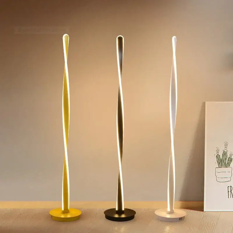 Three modern twist-design aluminum floor lamps in yellow gold and white with dimmable led lighting by decorbites