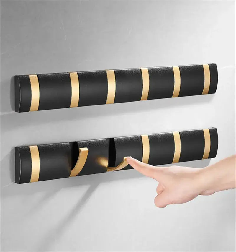 Decorbites aluminum folding robe hook in black gold features a wall-mounted striped coat rack with modern design