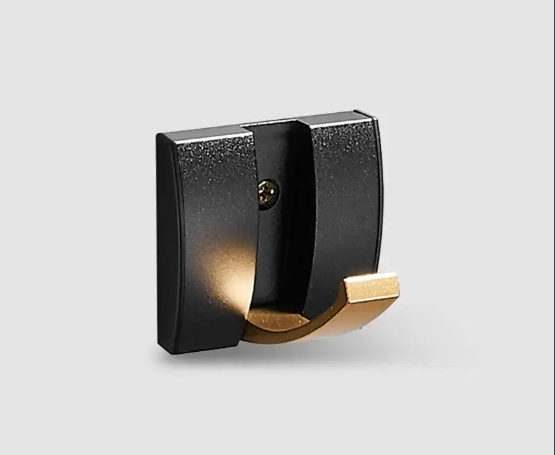 Decorbites™ aluminum folding robe hook in black and gold with matte black base and polished brass hooks for wall mounting