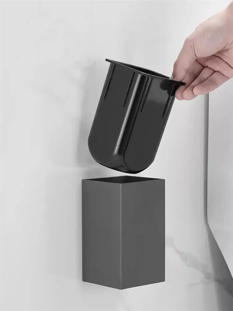Black plastic wall-mounted brush holder with vertical ridges included in the DecorBites™ aluminum gray white toilet brush holder set