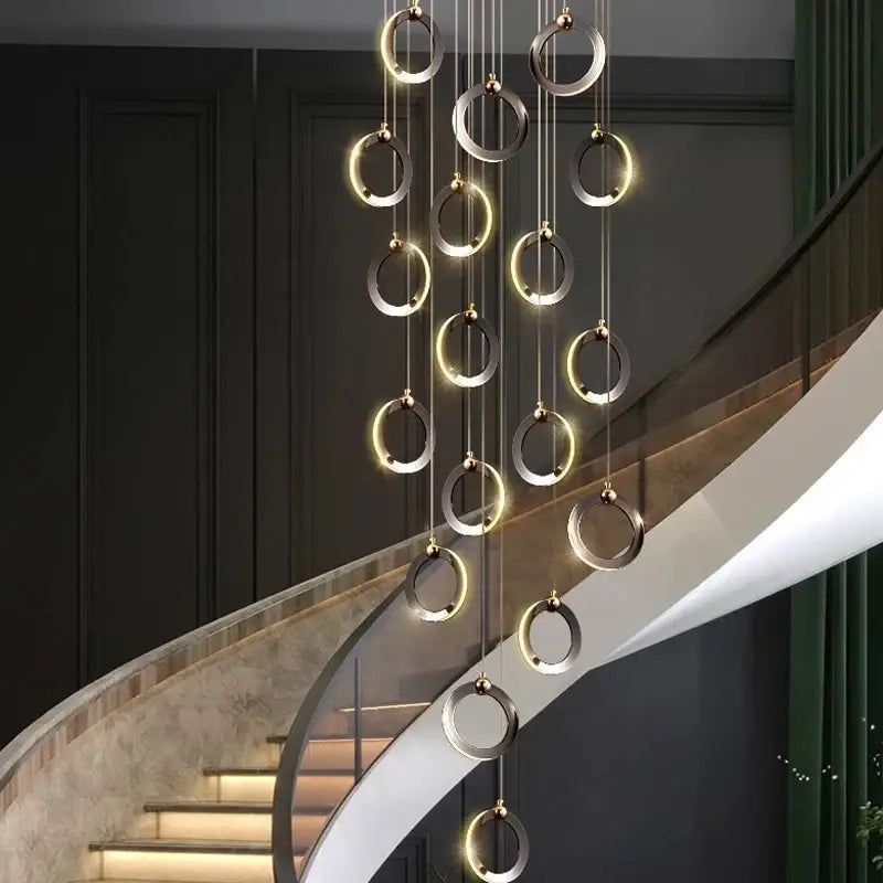 Modern minimalist aluminum led chandelier with polished metallic rings emitting warm ambient light for luxury staircases