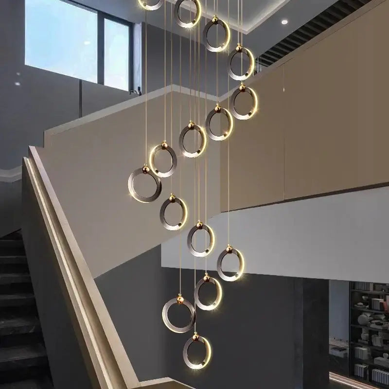 Decorbites aluminum led chandelier with brushed gold and silver rings emitting warm glow for staircase and attic lighting