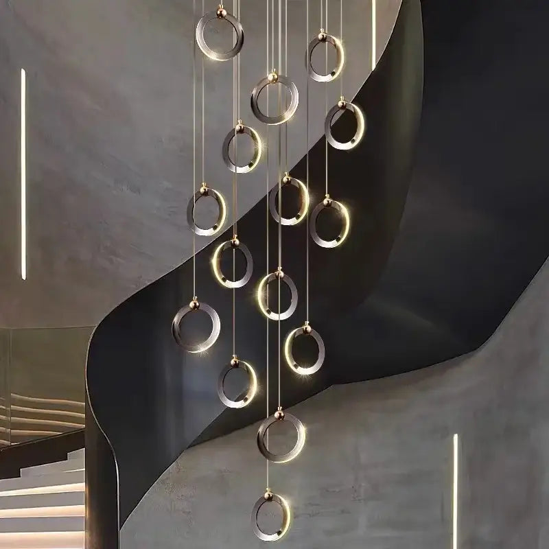 Modern minimalist aluminum led chandelier with polished metallic rings emitting warm ambient glow for staircase and attic