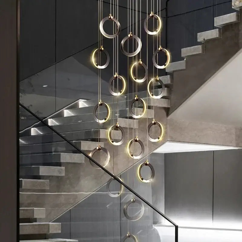 Modern minimalist aluminum led chandelier by DecorBites featuring interlocking silver and gold rings for staircase lighting