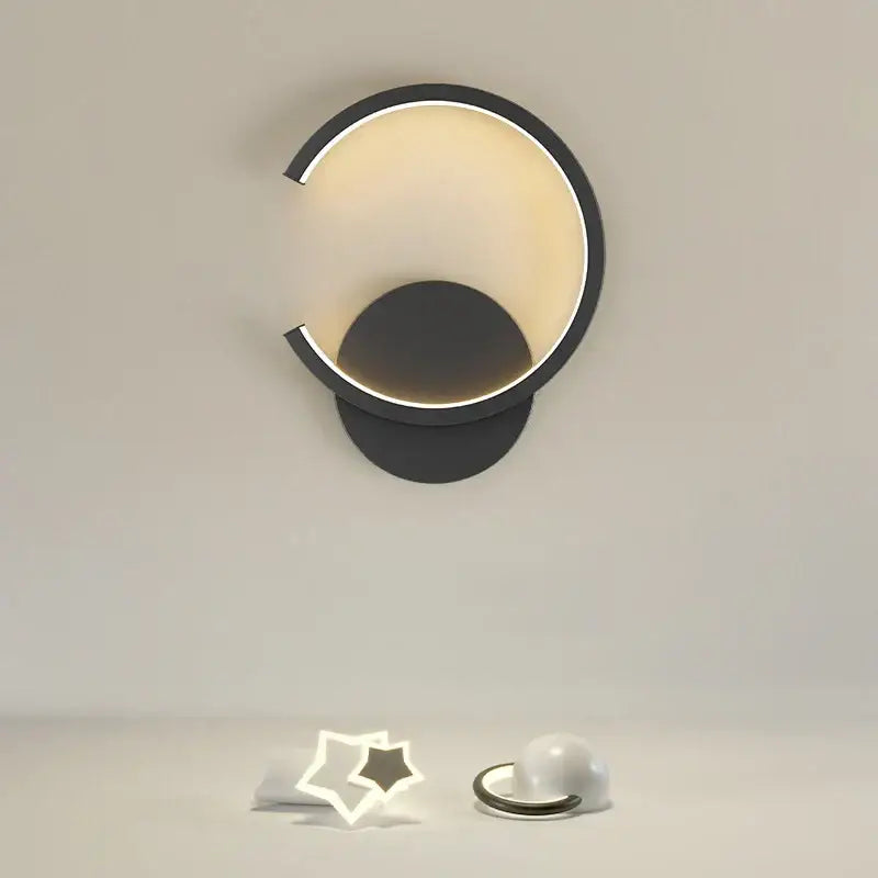 Modern black crescent-shaped aluminum led wall lamp with warm glowing interior light for bedroom and living room décor