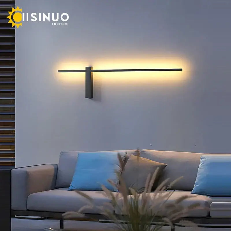 Modern black aluminum outdoor wall sconce with sleek horizontal bar emitting warm ambient light for porch and patio use