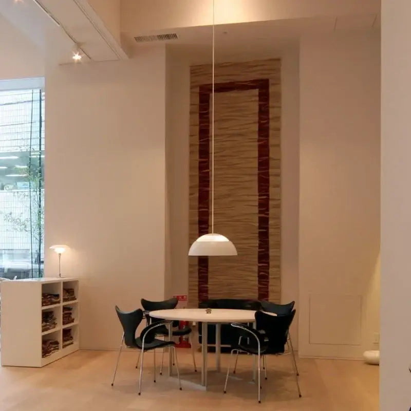 White decorbites aluminum pendant lamp with sleek dome-shaped shade suspended by thin cord for dining room lighting