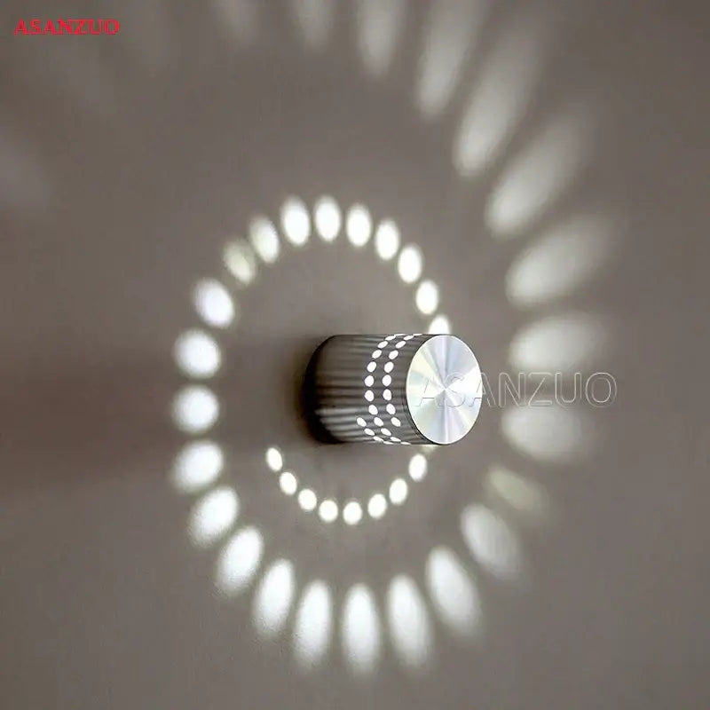 Silver decorbites aluminum spiral wall lamp with perforated design casting circular white light patterns