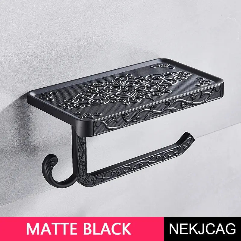 Matte black ornate aluminum toilet paper holder with intricate floral scrollwork and phone rack by decorbites