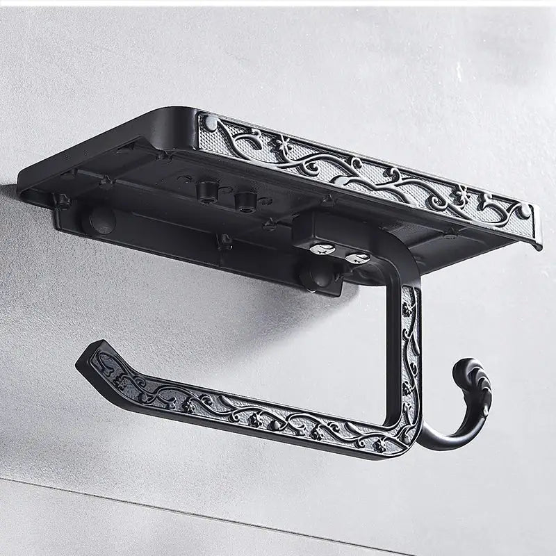 Black ornate aluminum toilet paper holder with intricate scrollwork design and phone rack in decorbites™ collection