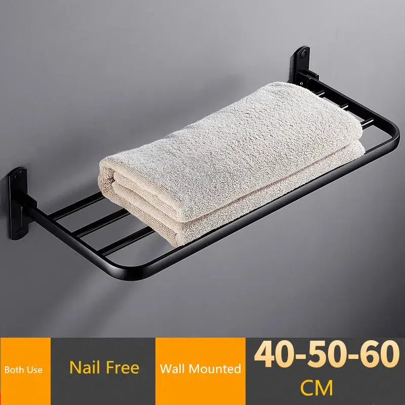 Black metal wall-mounted decorbites aluminum towel rack holding a folded off-white terry cloth towel for bathroom use
