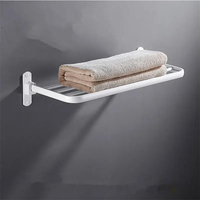 White metal wall-mounted decorbites aluminum towel rack holding two folded beige towels in bathroom setting
