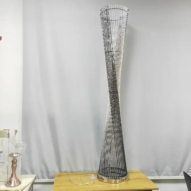 Modern silver twisted aluminum tower floor lamp with beaded design and metallic base for living room use