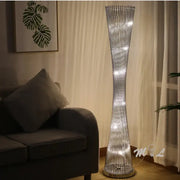 Silver slender decorbites aluminum tower floor lamp with twisted wireframe and embedded led lights for living room use