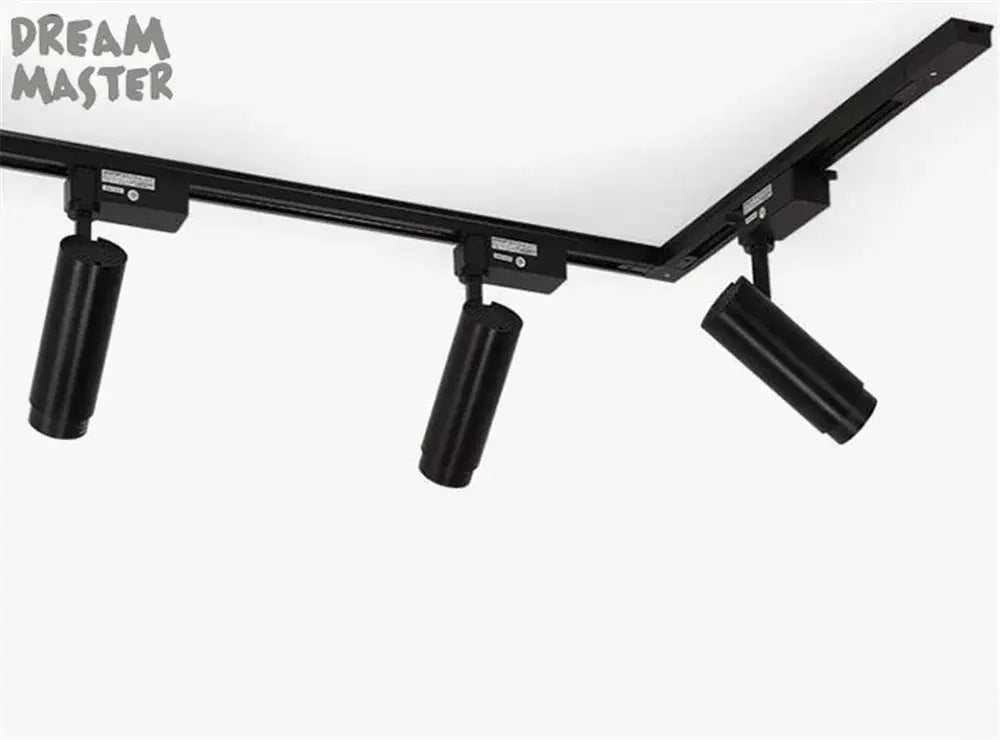 Black cylindrical LED spotlights mounted on decorbites aluminum track rails with t-l connector in sleek design