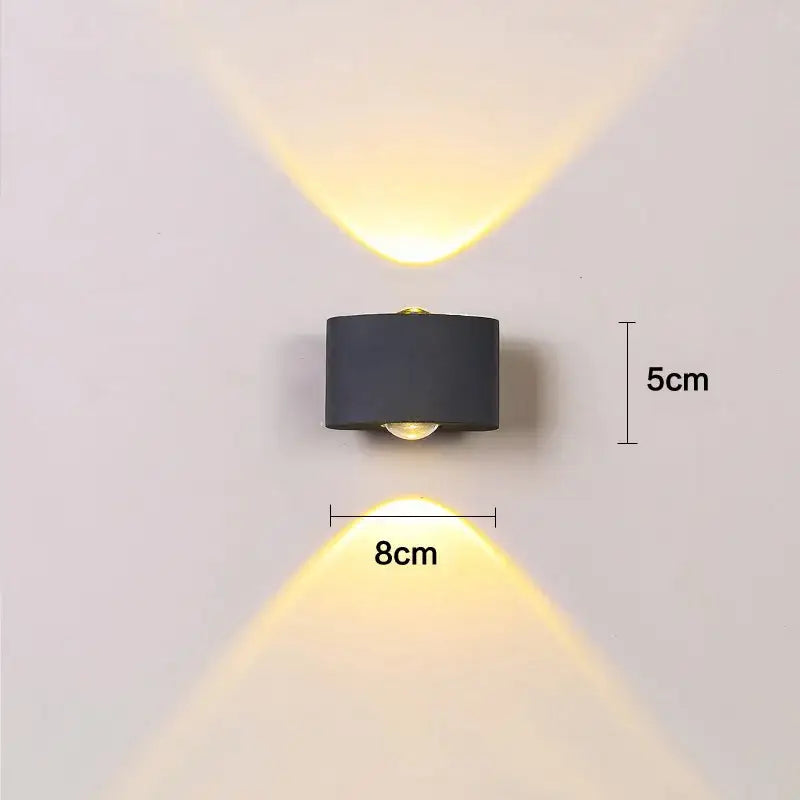 Black decorbites aluminum wall lamps with dual angled beams emitting warm yellow light for bedside and living room use