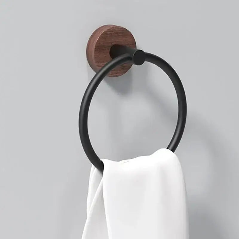 Black metal towel ring with walnut circular base holding a white towel for bathroom and kitchen wall mount use