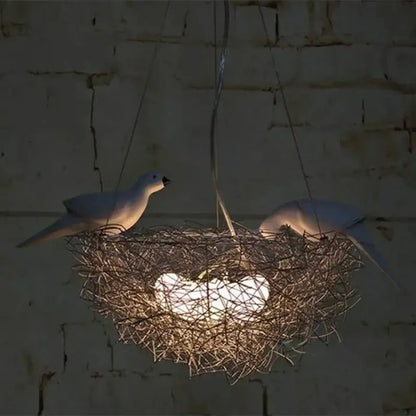 A DecorBites aluminum wire bird’s nest pendant light with white ceramic birds and an illuminated heart-shaped bulb