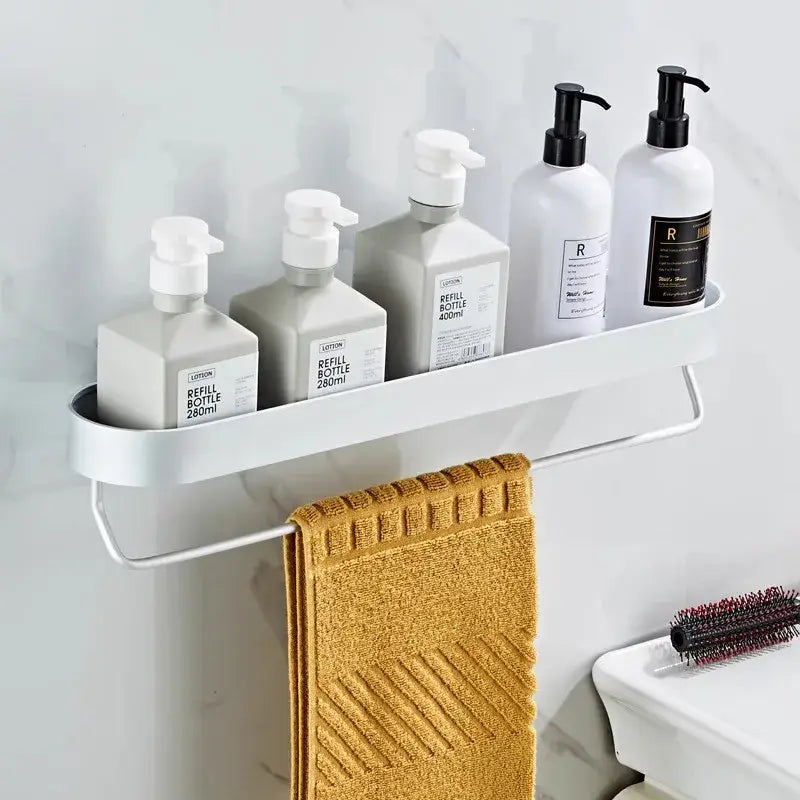 White DecorBites™ aluminum bathroom shelf with towel bar and corner storage shelf holding lotion bottles and towel