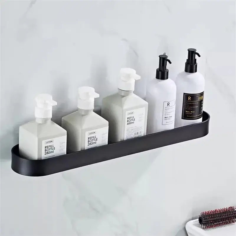 Black metal decorbites bathroom shelf with towel bar and corner storage shelf holding white and gray pump bottles