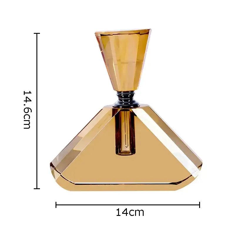 A faceted amber crystal perfume bottle with a geometric pyramid base and tapered neck by DecorBites for aromatherapy use