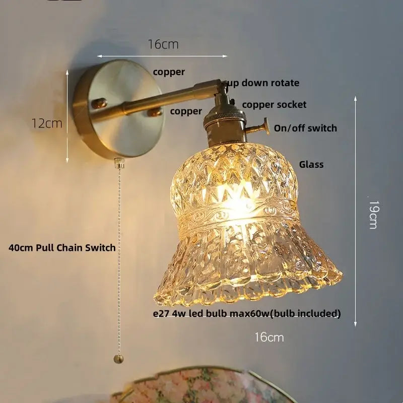 DecorBites amber flower glass led wall light features an antique brass finish with a clear faceted bell shade