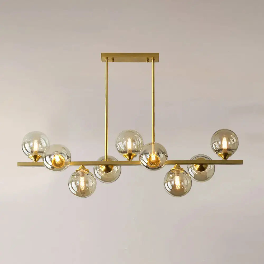 Gold-toned DecorBites™ amber glass chandelier with clear globe bulbs and sleek horizontal bar for dining room lighting