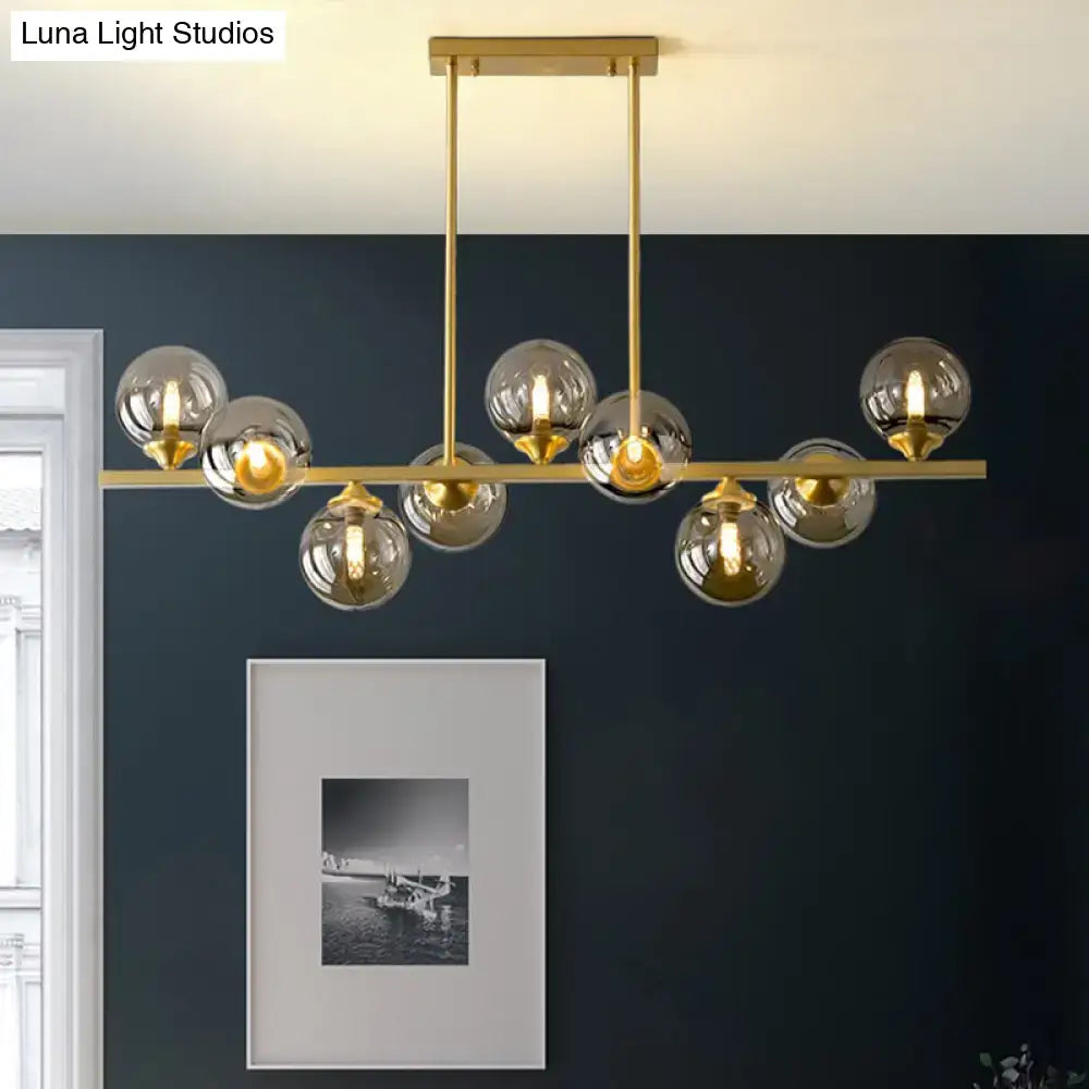 Gold-toned DecorBites™ amber glass bubbles island lamp with spherical glass globes for modern dining room lighting