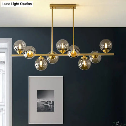 Gold-toned DecorBites™ amber glass bubbles island lamp with spherical glass globes for modern dining room lighting