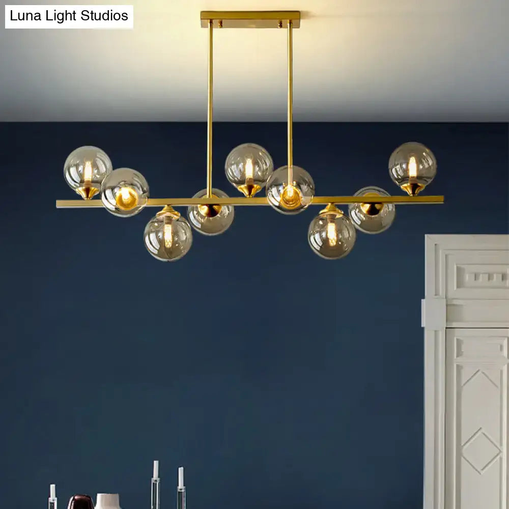 DecorBites™ modern gold hanging light with clear glass globe bulbs and amber glass accents for dining room island