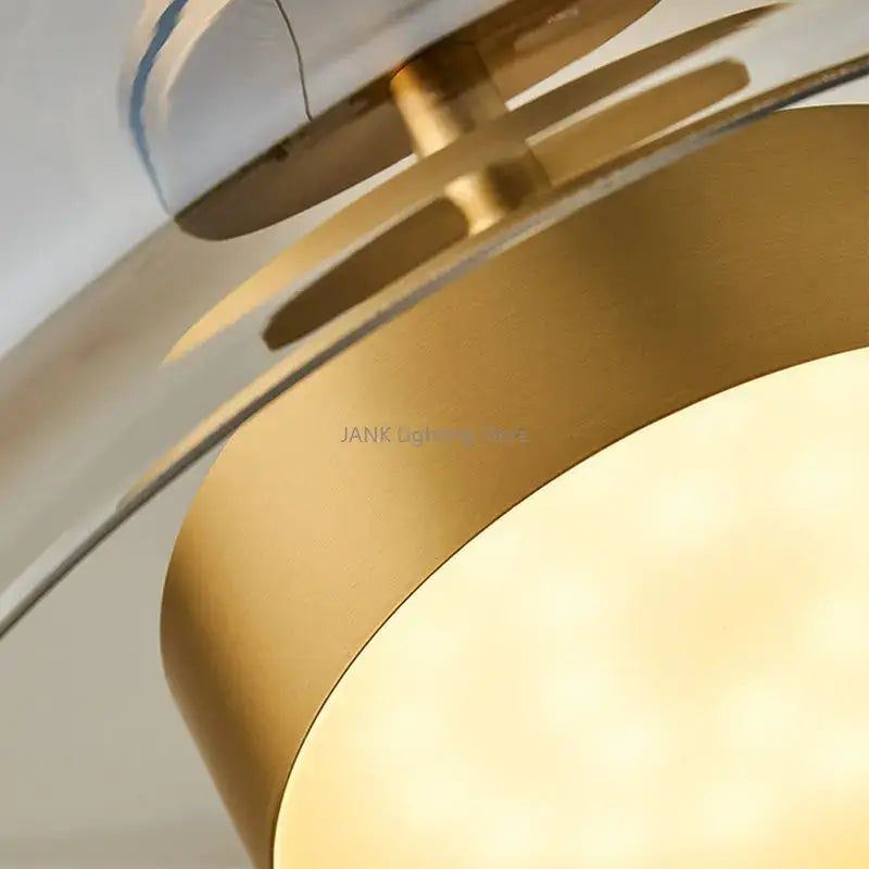 Modern brass-finished amber glass chandelier pendant light with layered circular design and warm ambient glow for living spaces
