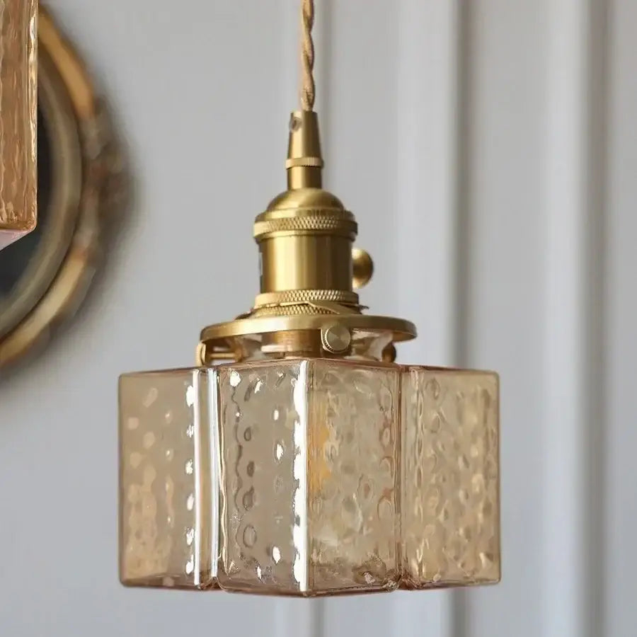 A vintage-style brass led pendant light with amber-tinted textured glass cube shade for kitchen or bedroom
