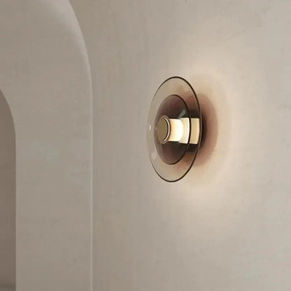 Decorbites amber glass disc wall lamp featuring a modern minimalist amber-tinted glass disc wall sconce design