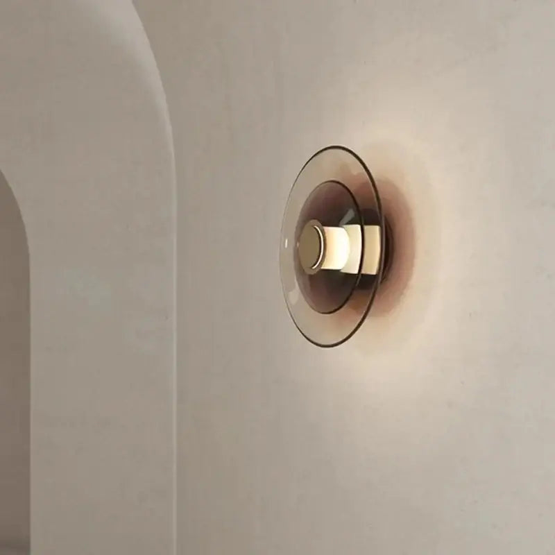 Decorbites amber glass disc wall lamp featuring a modern minimalist amber-tinted glass disc wall sconce design