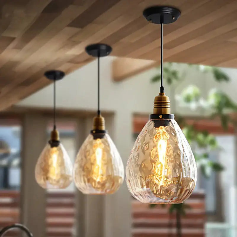 DecorBites amber glass industrial pendant lights with teardrop-shaped textured amber glass and brass hardware for dining