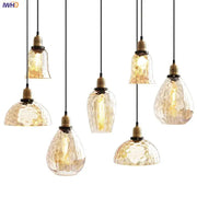 Set of seven amber glass industrial pendant lights with textured design and brass fixtures for vintage decor