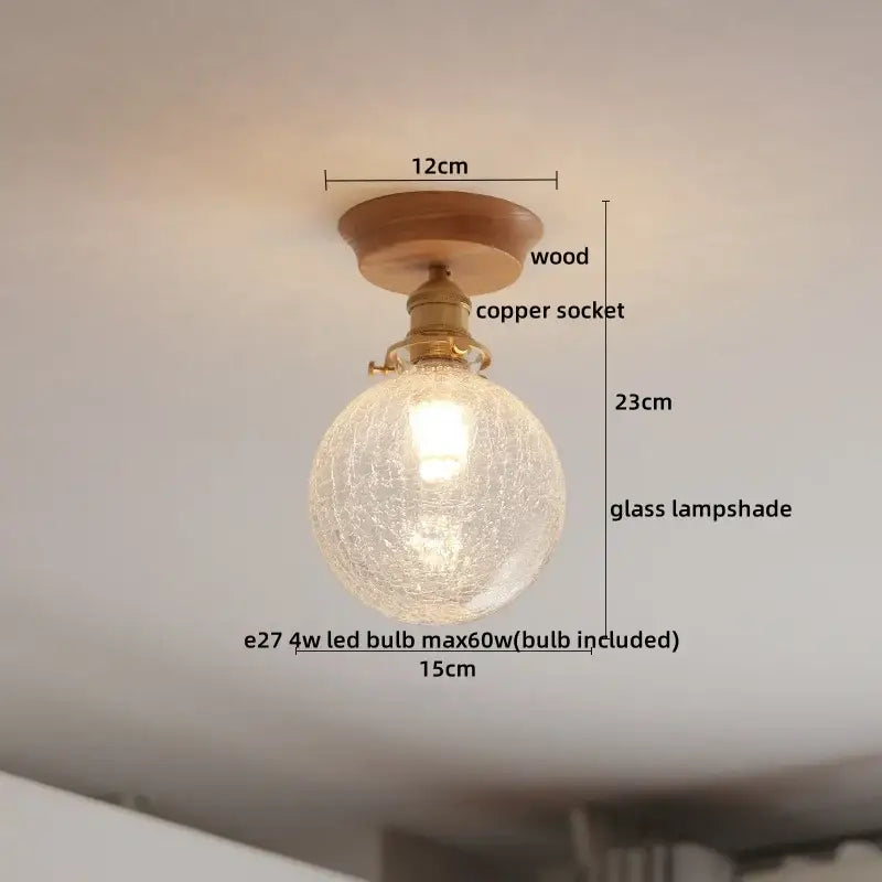 A round crackled amber glass led ceiling light with warm glow on brass copper socket and wooden mount for modern decor