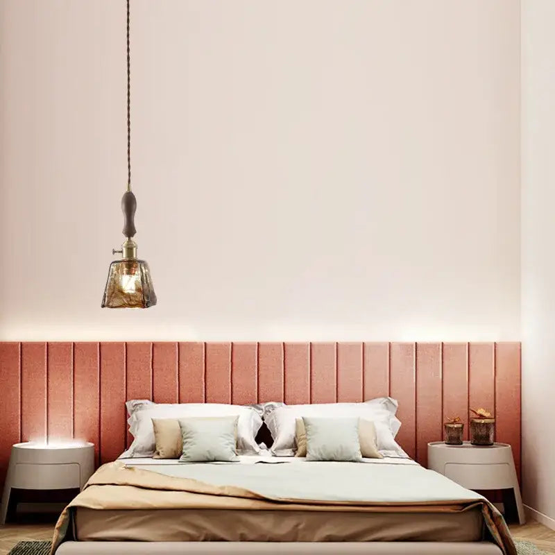 DecorBites amber glass led hanging lamp with brass fixture and dark textured cord over bed for vintage loft decor