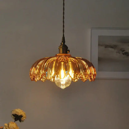 Decorbites amber glass led pendant lamp with golden petal-shaped glass and brass-finished fixture with black cord