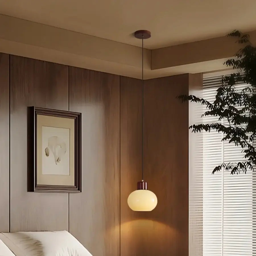 A decorbites amber glass pendant light with matte brass finish and frosted shade for rustic kitchen cafe interiors