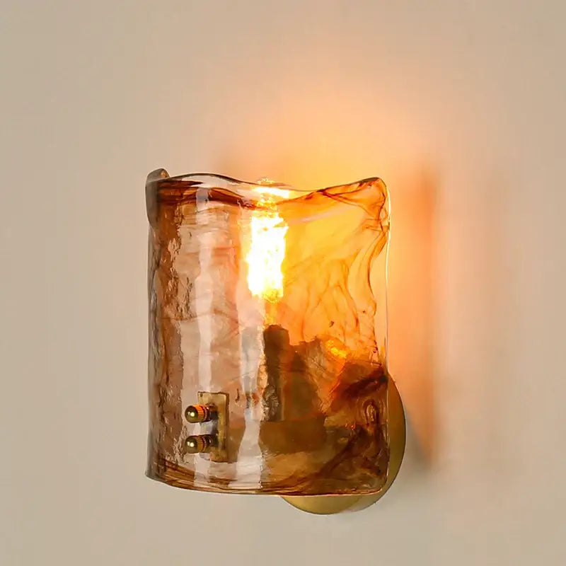 Warm amber glass led wall lamp with textured hand blown finish and brass hardware for bedroom lighting