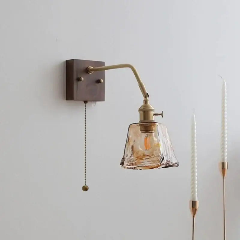 Brass wall sconce with decorbites amber glass led shade and adjustable arm featuring pull chain switch