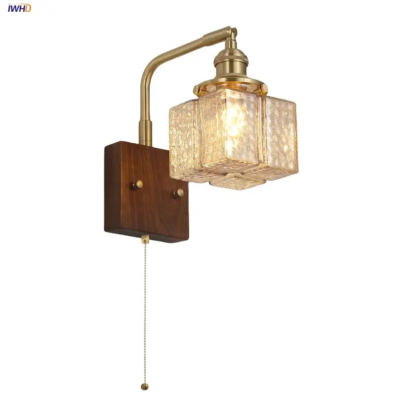Brass finished wall sconce with amber glass cube and walnut wood mounting plate featuring pull chain switch