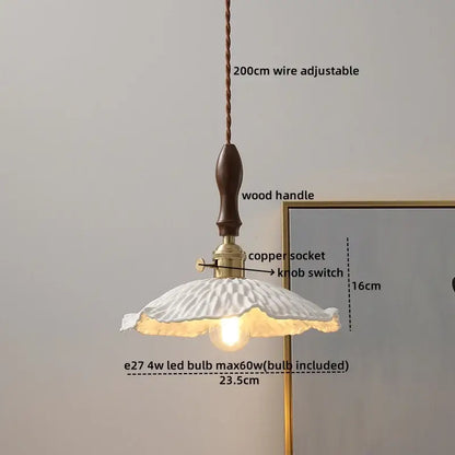 A white fluted ceramic pendant light with dark wood handle and brass accents for decorbites amber glass pendant lamps