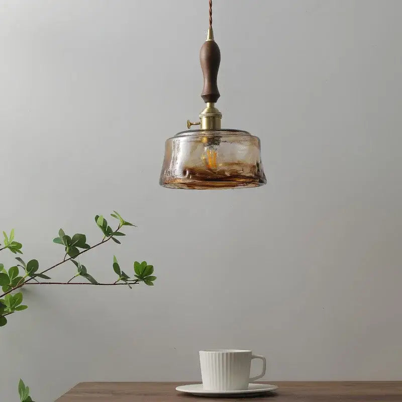 DecorBites amber glass pendant lamp with warm amber glass, brass fixture, and dark wood handle for modern interiors