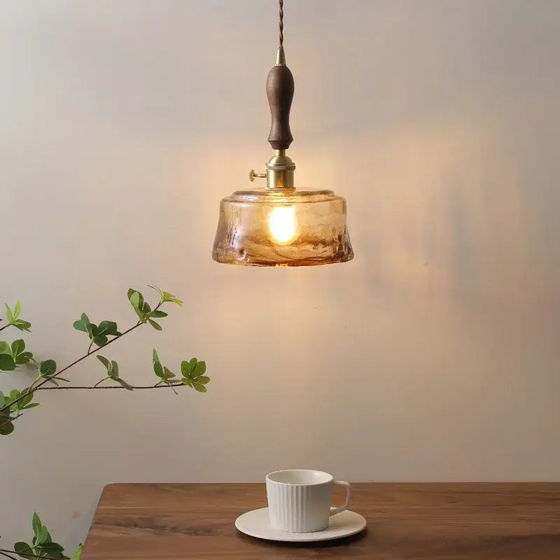 Warm amber glass pendant light with wooden handle and brass hardware from decorbites amber glass pendant lamps collection
