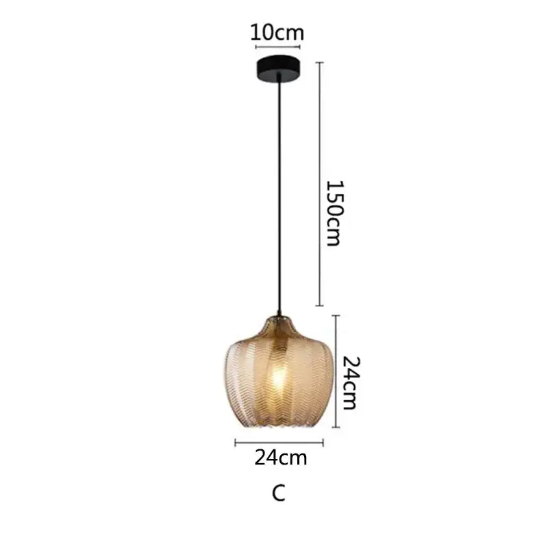 A modern decorbites amber glass pendant light with textured amber glass shade and black metal hardware for kitchen use