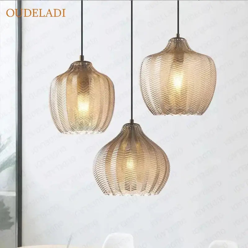 Three amber glass pendant lights with textured wavy pattern and black cords from decorbites amber glass collection